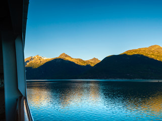 Wall Mural - Early morning sunrise light on mountains, from deck of cruise ship, Taiya Inlet, Skagway, Alaska, USA.