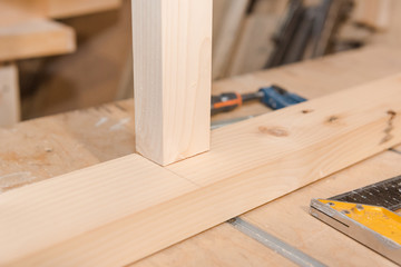 Wall Mural - A man is screwing a screw into a wooden table. Carpentry workshop. Work with a screwdriver.