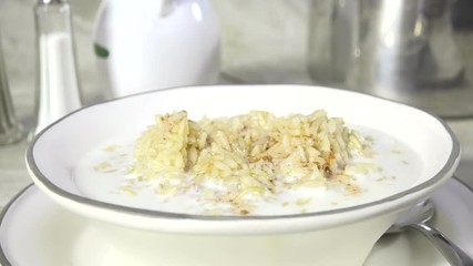 Wall Mural - Toping a bowl of hot rice with milk with cinnamon