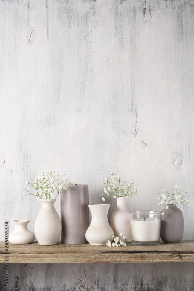 White flowers in neutral colored vases and candles - obrazy, fototapety, plakaty 