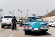 A traffic jam in Malibu, California with a vintage convertible car, motorcycle and pick up truck in summer time