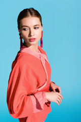 fashionable girl posing in trendy living coral clothing isolated on blue