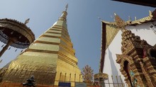 Wat Phra That Cho Hae, The Royal Temple In Phrae Province,Thailand, Showing The Golden Pagoda With Golden Umbrella At And Stupa The Corner With Blue Sky Background.