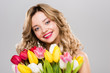 © LIGHTFIELD STUDIOS - young attractive spring woman holding colorful tulips isolated on grey