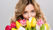© LIGHTFIELD STUDIOS - young spring woman holding bouquet of colorful tulips isolated on grey