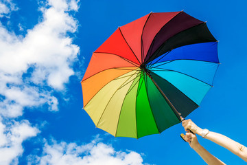multi-colored umbrella on the sky background.girl holding an umbrella