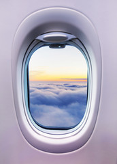 Wall Mural - airplane interior with window view of sunset above clouds.
