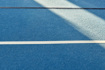 Colorful gym floor with diagonal color blocks. Background texture. Blue, black, white and yellow colors. Exercise concept, indoors sports, gymnastics. Morning sun.