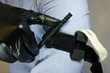 Person in black medical gloves Applies the tourniquet to his hand to prevent bleeding during the first aid. Trauma patient. Combat tactical Equipment. Combat Application Tourniquet