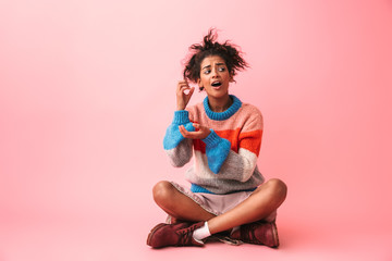 Wall Mural - Funny beautiful young african woman posing isolated over pink wall background.