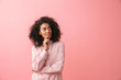 © Drobot Dean - Happy beautiful young african woman posing isolated over pink wall background.