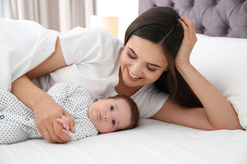 Sticker - Happy woman with her cute baby on bed