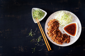 Wall Mural - Japanese cuisine. Deep-fried pork chop, or Japanese chop with cabbage and tonkatsu sauce. Top view