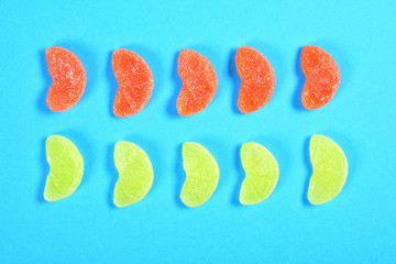 Wall Mural - group of jelly candies piece of orange fruit color yellow and orange on blue background