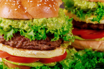 Homemade burger with eggs bun, beef patty, guacamole cutting board