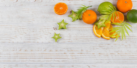 Wall Mural - Green palm leaves and fresh tropical slices of fruits