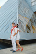 © CRISTINA - Young happy couple standing over glass of window background.