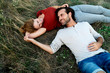 © Westend61 - Happy couple cuddling, lying on a meadow