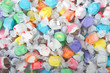 Background of salt water taffy in various flavors and colors wrapped in white transparent paper. Salt water taffy is sold widely on the boardwalks in the U.S. and Canada.
