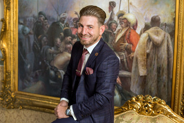 Handsome man posing on armchair in luxury hotel room