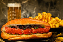 Hotdogs With Glass Of Beer With French Fries On Wooden Board