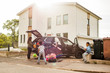 © Maskot - Family with electric car on driveway against house