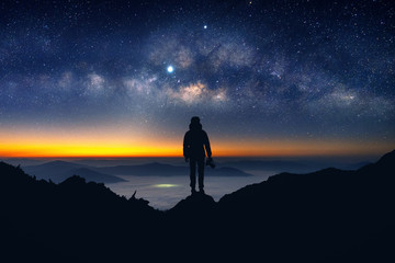 silhouette of photographer with camera and milky way blackground.
