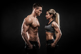 Sporty young couple posing on black background