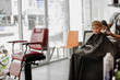 © demphoto - Little boy sitting in armchair in barbershop and having new haircut