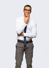 Wall Mural - Young afro american businessman with glasses and smiling on isolated background