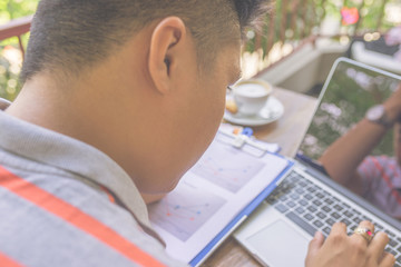 Wall Mural - Close-up of young Asian businessman surfing Internet on laptop