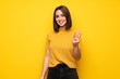 © luismolinero - Young woman over yellow wall happy and counting three with fingers