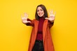 © luismolinero - Young woman with coat counting ten with fingers