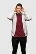 © luismolinero - Man with sweatshirt frustrated and takes hands on head over grey background