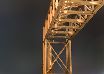 Steel support of boiler pipe in the factory on blue dark night sky background.