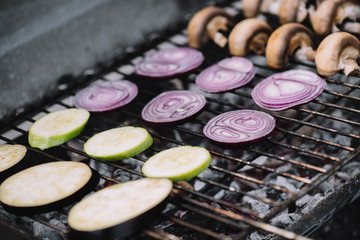 Canvas Print - selective focus of raw onion slices, zucchini and mushrooms grilling on barbecue grid