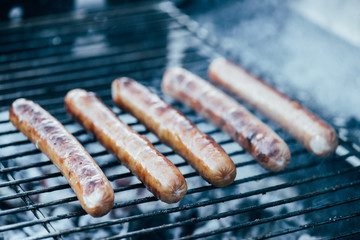 Poster - selective focus of tasty grilled sausages on bbq grill grade