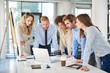 © nenadaksic - Small group of business people standing at office and solving problem at meeting. Multi cultural group.