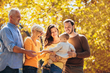 Wall Mural - Multl generation family in autumn park having fun