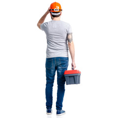 Man with building tools box and helmet in hand on white background isolation, back view