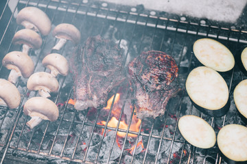 Canvas Print - selective focus of juicy tasty steaks grilling on bbq grid with mushrooms and sliced eggplant