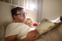 Father Reading Bedtime Stories To Child. Dad Putting Son To Sleep