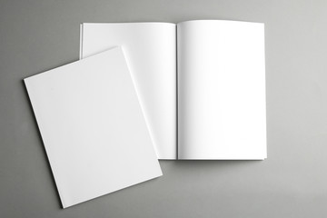 open and closed blank brochures on grey background, top view. mock up for design