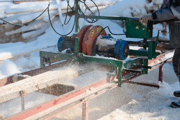 Wall Mural - Sawing boards on the sawmill. Cook lumber in winter. Work on the sawmill.