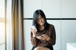 © gballgiggs - Asian woman using cell phone searching information and reading drug or pill label and prescription medications
