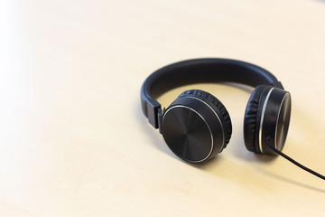 Black headphones on wooden table background