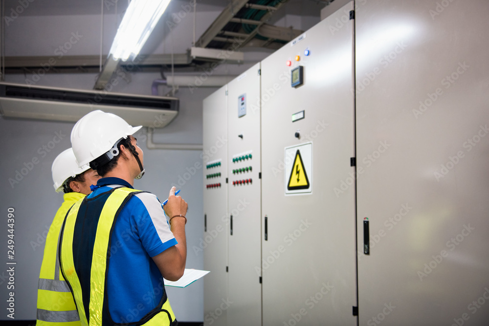 Electrical engineer in the control room and recording in operation of ...