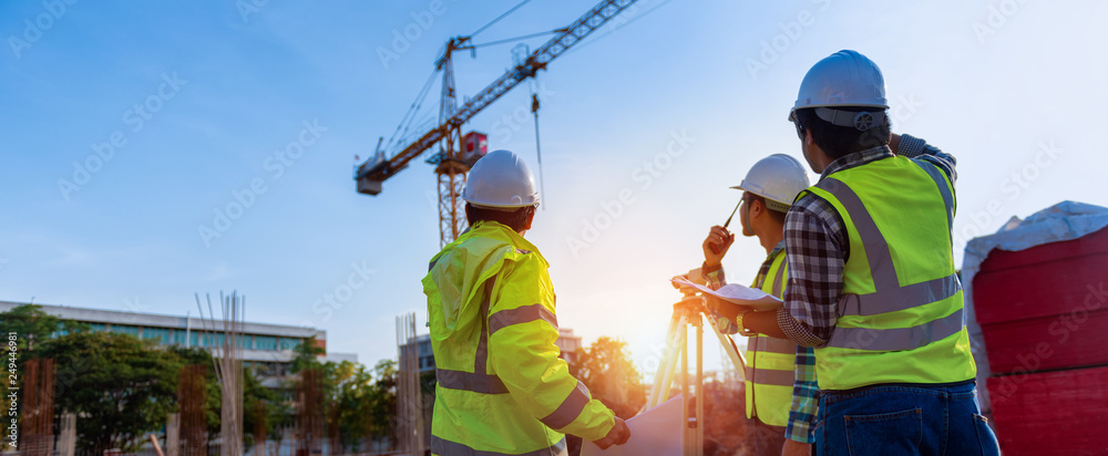 Construction engineers discussion with architects at construction site or building site of highrise building with Surveying for making contour plans is a graphical representation of the lay in land. - obrazy, fototapety, plakaty 