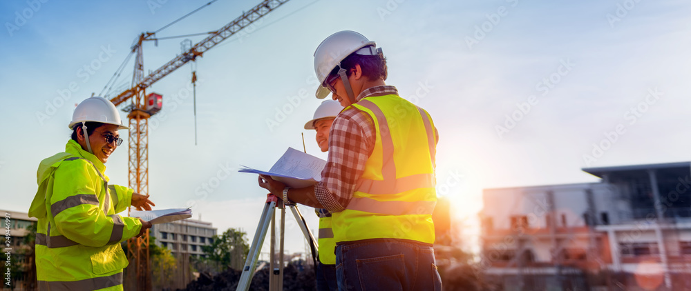 Construction engineers discussion with architects at construction site or building site of highrise building with Surveying for making contour plans is a graphical representation of the lay in land. - obrazy, fototapety, plakaty 