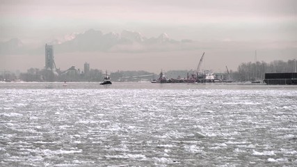 Wall Mural - Fraser River Tugboat and Ice. 4K. UHD. A tugboat travels down the icy Fraser River at dawn. 4K UHD.